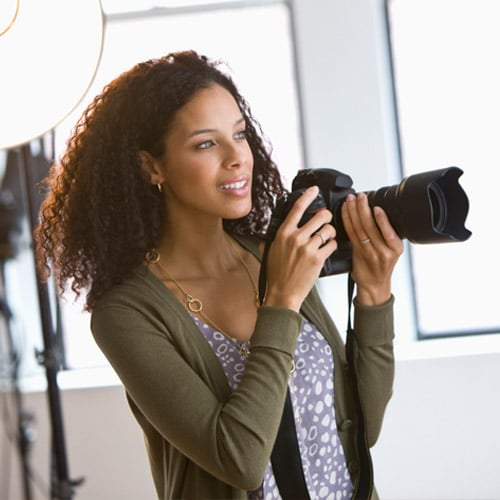 Photographer Career - woman taking photographs in photography studio