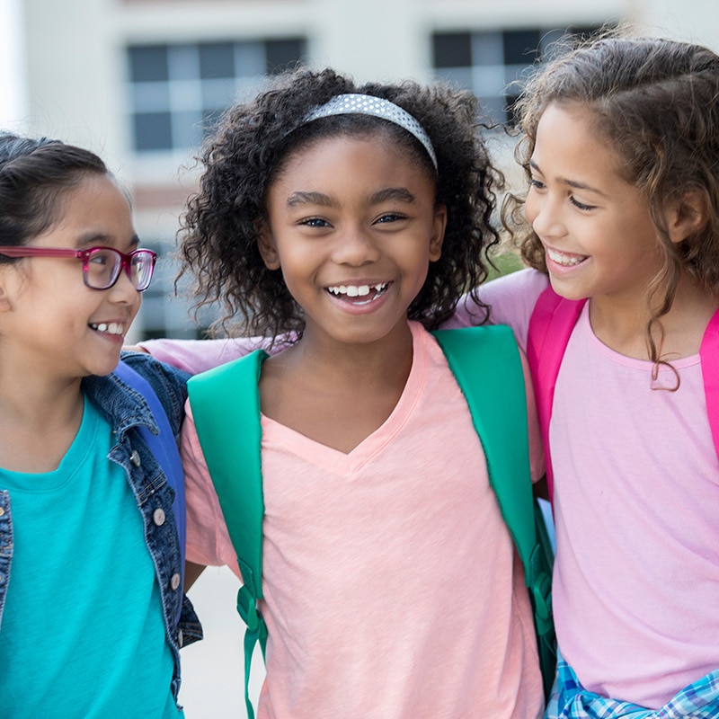 Three schoolgirls embrace on first day of school - Career Girls